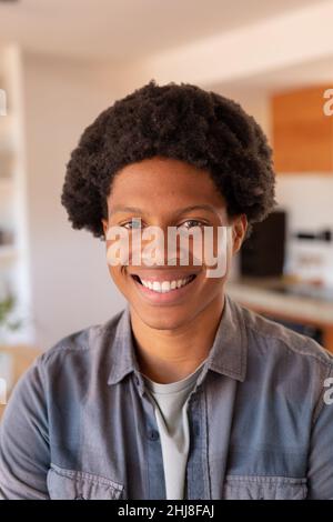 Close-up portrait of smiling african american young man with afro hairstyle. unaltered, lifestyle, leisure activity, hairstyle and domestic life conce Stock Photo