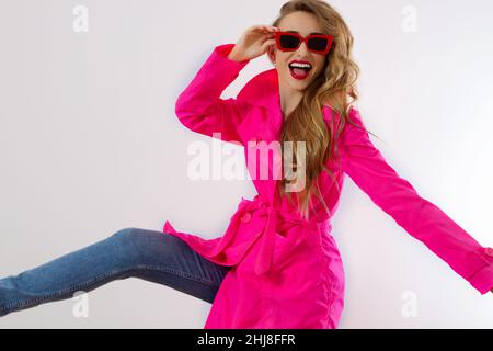 Close up happy girl in red sunglasses and pink coat isolated on white background. excited, shock and surprised young woman, trendy outfit. Fashion and Stock Photo