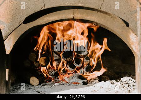 Close-up of barbecue grill, homemade pizza, putting the pizza in the wood-fired oven to bake Stock Photo