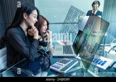Group Of Asian Business people with casual suit working with technology laptop showing the Stock market exchange information and Trading graphin the m Stock Photo
