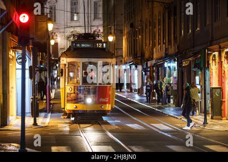 Lisbon, Portugal - November 18 2021: An iconic tram car wait at a traffic light in Lisbon historic center at night. Stock Photo