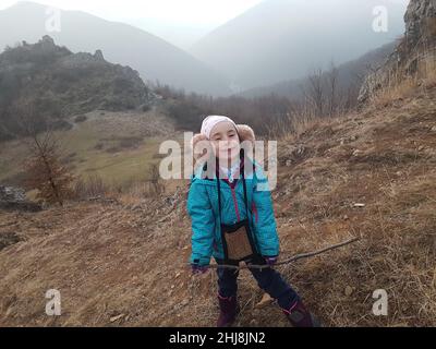 Cute young girl, kid posing with winter ear cap in the outdoors Stock Photo