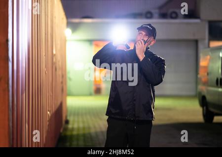 Security Guard At Cargo Container Storage Terminal At Night Stock Photo