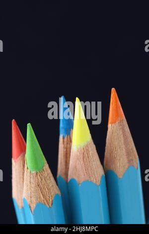 Bright coloured pencils sharpened to fine points on dark background Stock Photo