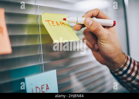 Faceless male worker making notes on paper Stock Photo