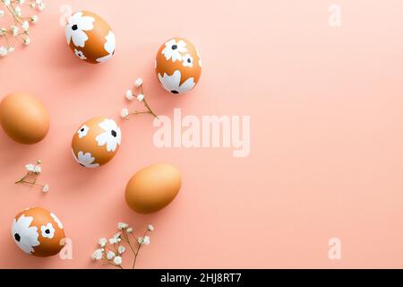 Painted Easter eggs and gypsophila flowers on pastel pink background. Happy Easter concept. Minimal style. Stock Photo