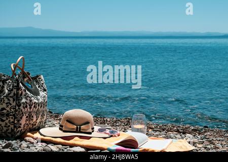 Summer holiday concept at seaside with bag, towel, sunglasses, hat and a book, leisure activity at the beach in vacation Stock Photo