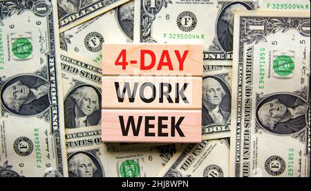 4-day work week symbol. Concept words 4-day work week on wooden blocks on beautiful background from dollar bills. Copy space. Business and 4-day work Stock Photo