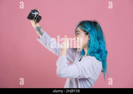 young woman taking a selfie with her analog camera Stock Photo