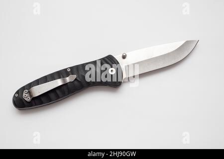 Folding hunting knife with black handle on white background. Stock Photo