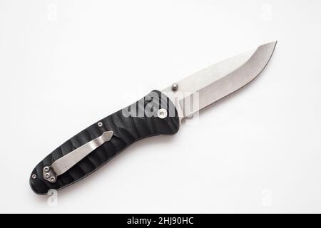 Folding hunting knife with black handle on white background. Stock Photo