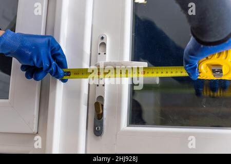 service man installing window with measure tape Stock Photo