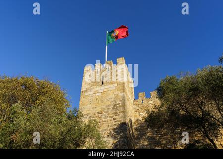 Portuguese flag above the Sao Jorge castle, or Saint Georges, in Lisbon old town in Portugal on a sunny day Stock Photo