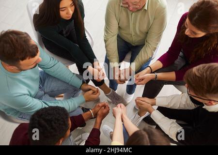 Multiracial group of men and women having group therapy session with psychotherapist Stock Photo