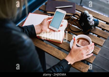 Unrecognizable woman using phone in cafe Stock Photo