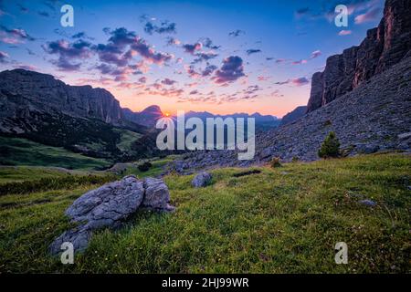 Rock faces of the Sella group at right, Puez group and Mt. Sassongher at left, seen from Gardena Pass at sunrise. Stock Photo