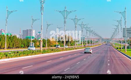 Urban city scape of Ashgabat city center with wide highway and light traffic. High white marble buildings by sides. Ashgabat is the capital of Turkmen Stock Photo