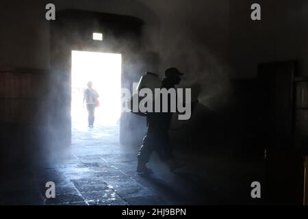 Sanitizer Daniela Guerrero  sprays disinfectant inside a temple as attempt to avoid the increase in infections by the new Omicron variant of the Covid Stock Photo