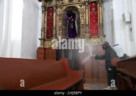 Sanitizer Daniela Guerrero  sprays disinfectant inside a temple as attempt to avoid the increase in infections by the new Omicron variant of the Covid Stock Photo