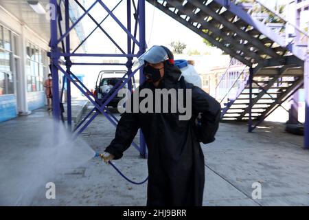 Sanitizer Daniela Guerrero  sprays disinfectant inside  facilities of a school as attempt to avoid the increase in infections by the new Omicron varia Stock Photo