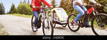 Family Riding Electric Mountain Bike Or Bicycle In Mountains Stock Photo
