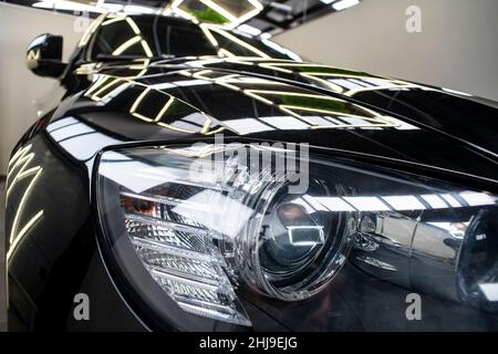 Head lights of a black, big, aggressive car , with neon reflections. Stock Photo