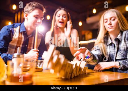 Young people have fun playing board games at a table . Stock Photo