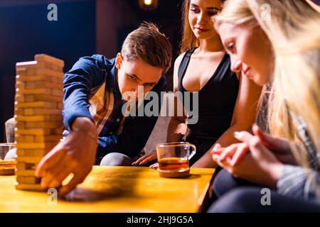 Young people have fun playing board games at a table Stock Photo