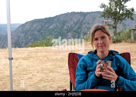 Mature Female Having Breakfast In Camping Site Stock Photo