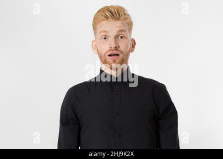 Excited surprised shock young shouting man isolated on gray background. Happy Redhead guy with red beard in black stylish shirt. Success and pass exam Stock Photo