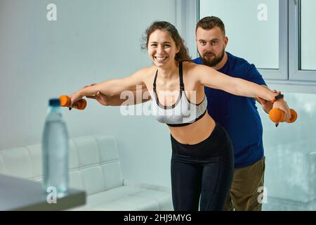 Fitness exercises with trainer and young woman inside. Stock Photo
