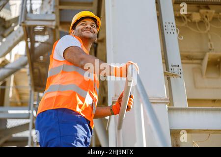 Smiling young construction engineer working in plant Stock Photo