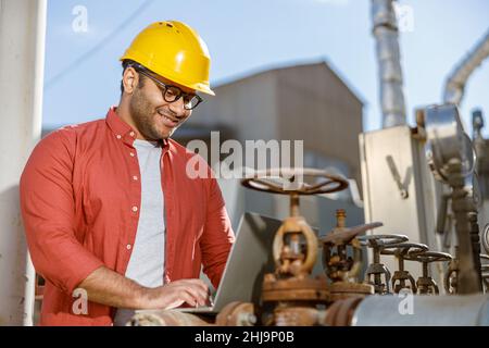 Smiling young construction specialist working in plant Stock Photo