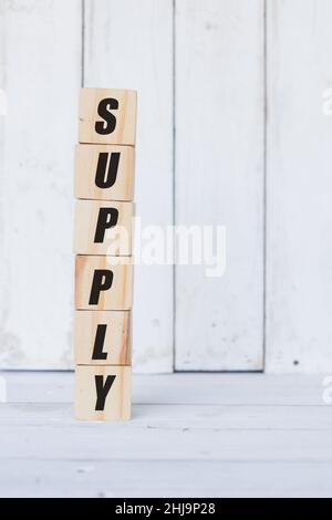 wooden cube, with the word supply, with white wooden background Stock Photo