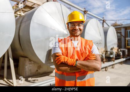 Smiling African engineer standing at industrial site Stock Photo