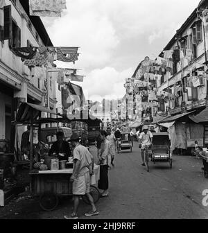 Scenes in Chinatown, Singapore, where old meets new. Clean washing is poked out from the windows from both old and new buildings as sleek limousines or trishaws make their way during the morning heat. 6th February 1962. Stock Photo