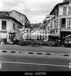 Scenes in Chinatown, Singapore, where old meets new. Clean washing is poked out from the windows from both old and new buildings as sleek limousines or trishaws make their way during the morning heat. 6th February 1962. Stock Photo
