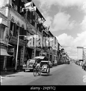 Scenes in Chinatown, Singapore. Upper Hokien Street, where old meets new. Clean washing is poked out from the windows from both old and new buildings as sleek limousines or trishaws make their way during the morning heat. 6th February 1962. Stock Photo