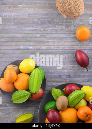 Varieties citrous on wooden background. Assorted citrus fruits and tamarillo. Exotic light meal and different fruitage. Copy space for your text. Stock Photo