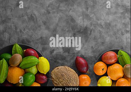 Bite still life on gray cement background. Different drupe fruits and tamarillo. Kiwi on vintage table and other fruits. Copy space for your text. Fru Stock Photo