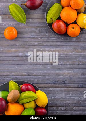 Citrus fruits on wooden background. Assorted citrus fruits and tamarillo. Coco on vintage table and different fruitage. Copy space for your text. Stock Photo