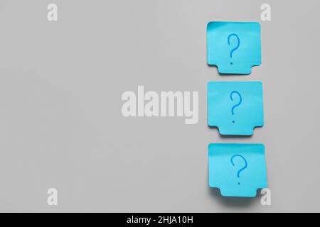 Sticky notes with question marks on grey background Stock Photo