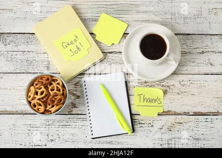 Cup of coffee, snacks and stationery on white wooden background Stock Photo