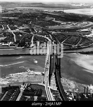Aerial view showing the new Runcorn - Widnes bridge across the River Mersey and Manchester Ship Canal. On the right of the picture is the bridge that it was built to replace, the Widnes-Runcorn Transporter Bridge. The bridge was officially opened on 21st July 1961 by Princess Alexandra. Circa 1962. Stock Photo