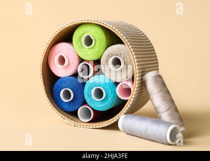 Box with different sewing thread spools on light background Stock Photo