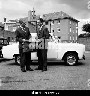 Ford Anglia in Police Yard, Bournemouth Police Station, the car was bought on Tuesday night from a local garage for 273 pounds, paid for in notes believed to have been stolen, Thursday 15th August 1963. Our Picture Shows ... left to right, Detective Superintendent Ben Bollard and Detective Chief Inspector Fred Tilling take a closer look at fishing bag which was left on the back seat of the Ford Anglia.   The first gang member of Great Train Robbery has been caught, Roger Cordrey, with his friend, William Boal.   They were living in a rented, fully furnished flat above a florist's shop in Wimbo Stock Photo