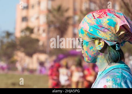 Valencia, Spain - April 27, 2019: Young woman portrait covered with multi colored powders during the "Holi life" race Stock Photo