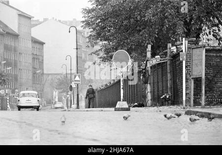 Scenes in Berlin, three years after work began on the construction of the Berlin Wall, separating East from West. Security patrol alongside the wall. 25th October 1964. Stock Photo