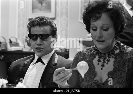 Filming on the set of the film 'Darling'. Unidentified man on the left, and Fanny Cradock on the right.  Darling is a 1965 British drama film written by Frederic Raphael, directed by John Schlesinger, and starring Julie Christie with Dirk Bogarde and Laurence Harvey.  Darling was nominated for five Academy Awards, including Best Picture and Best Director. Christie won the Academy Award for Best Actress for her performance as Diana Scott. The film also won the Academy Awards for Best Original Screenplay and Best Costume Design.  Picture taken 16th December 1964 Stock Photo