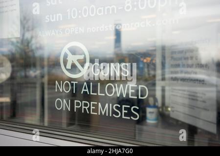 'Guns Not Allowed on Premises' warning sign is seen at the entrance to a Nordstrom Rack store in Portland, Oregon, on Friday, January 14, 2022. Stock Photo